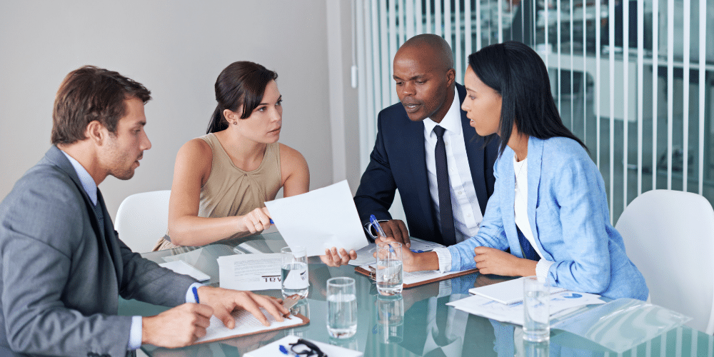 two men and two womens sitting on chairs talking to eachother